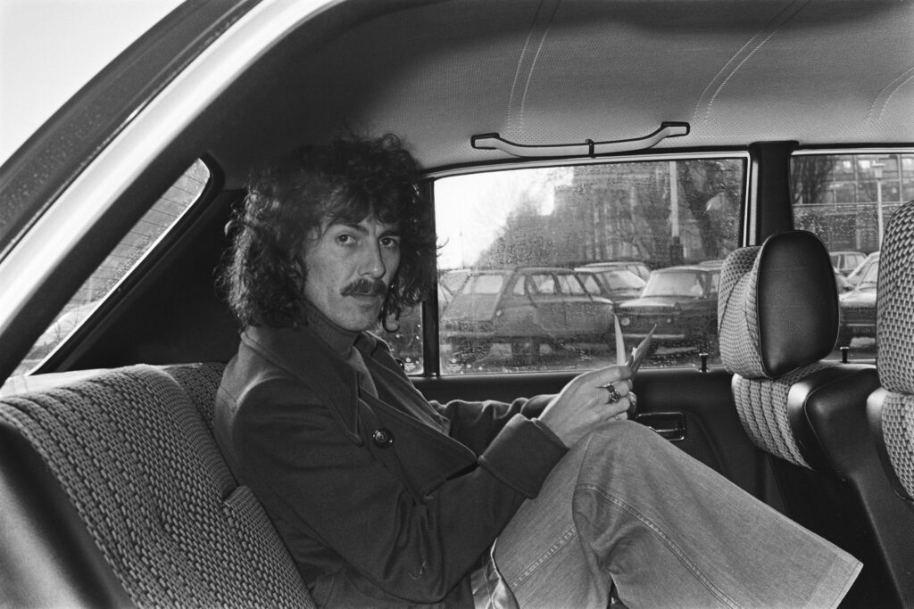 George Harrison achterin de auto