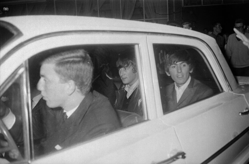 John en George achterin een auto