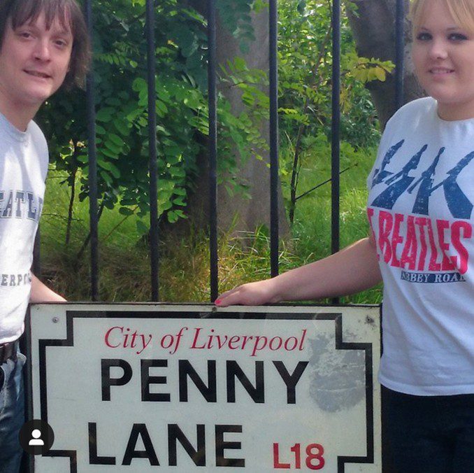 Ryan and Sarah at the Penny Lane sign on their honeymoon in Liverpool.